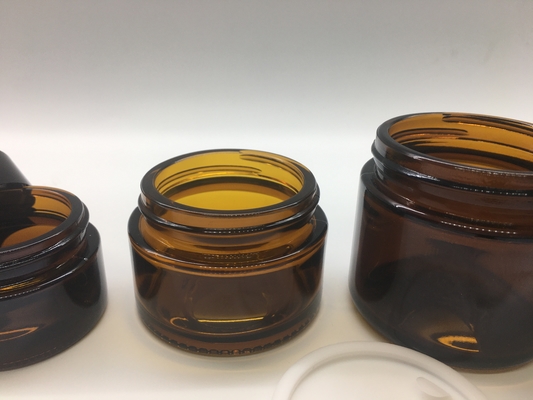 O reenchimento cosmético transparente Amber Glass Jar Straight Round dá forma com a tampa preta plástica